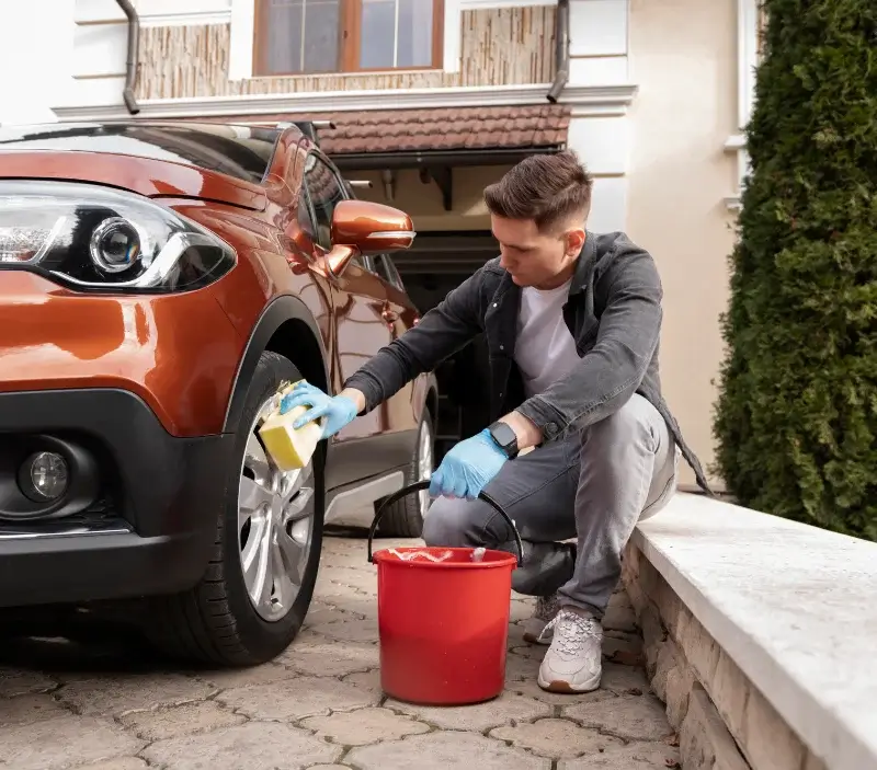 Lavage auto à domicile Husseren-Wesserling : professionnel intervenant sur un véhicule